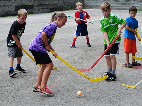 Campers playing street hockey